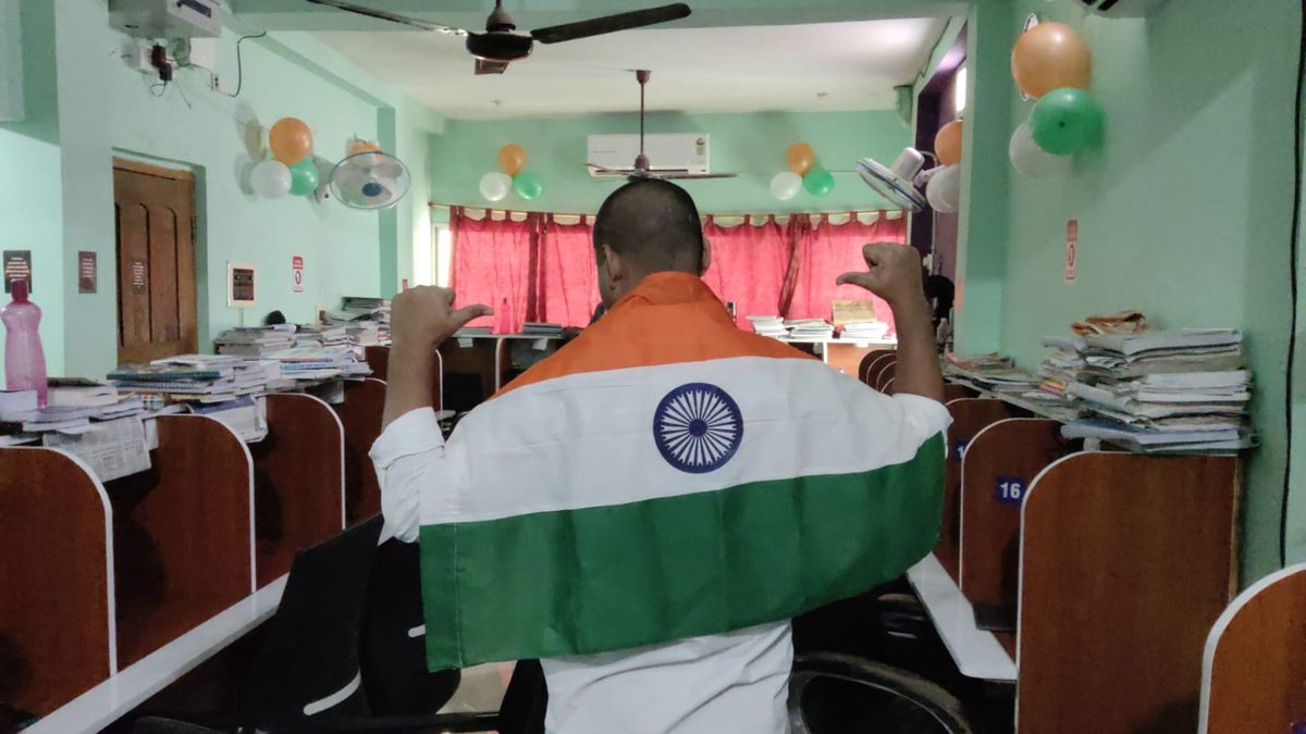 Student draped in the Indian flag standing in the study hall on Independence Day